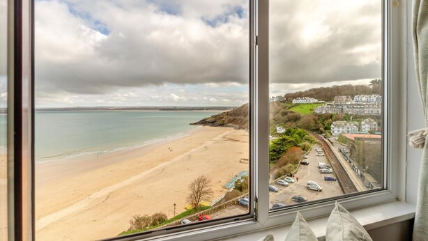 Blick auf einen Strand vom Fenster aus, mit Blick auf einen Parkplatz und ein Wohngebiet.