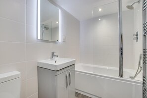 A modern bathroom with a glass-enclosed shower, a white sink, and a bathtub. - 2 Bed in St Ives (oc-tee009) (St Ives)