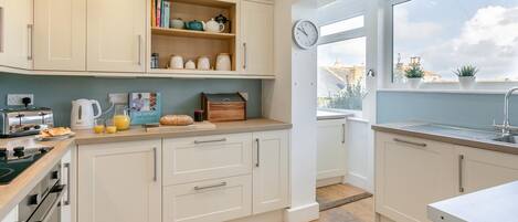 Een microgolfoven, een oven, een vaatwasser, kookgerei, borden en bestek