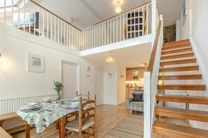 A spacious loft-style apartment with a dining area, kitchen, and a wooden staircase. - 2 Bed in St Ives (oc-redc2) (Saint Ives)