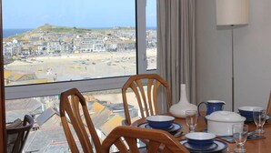 Espaço de refeições com vista para a praia e a cidade.