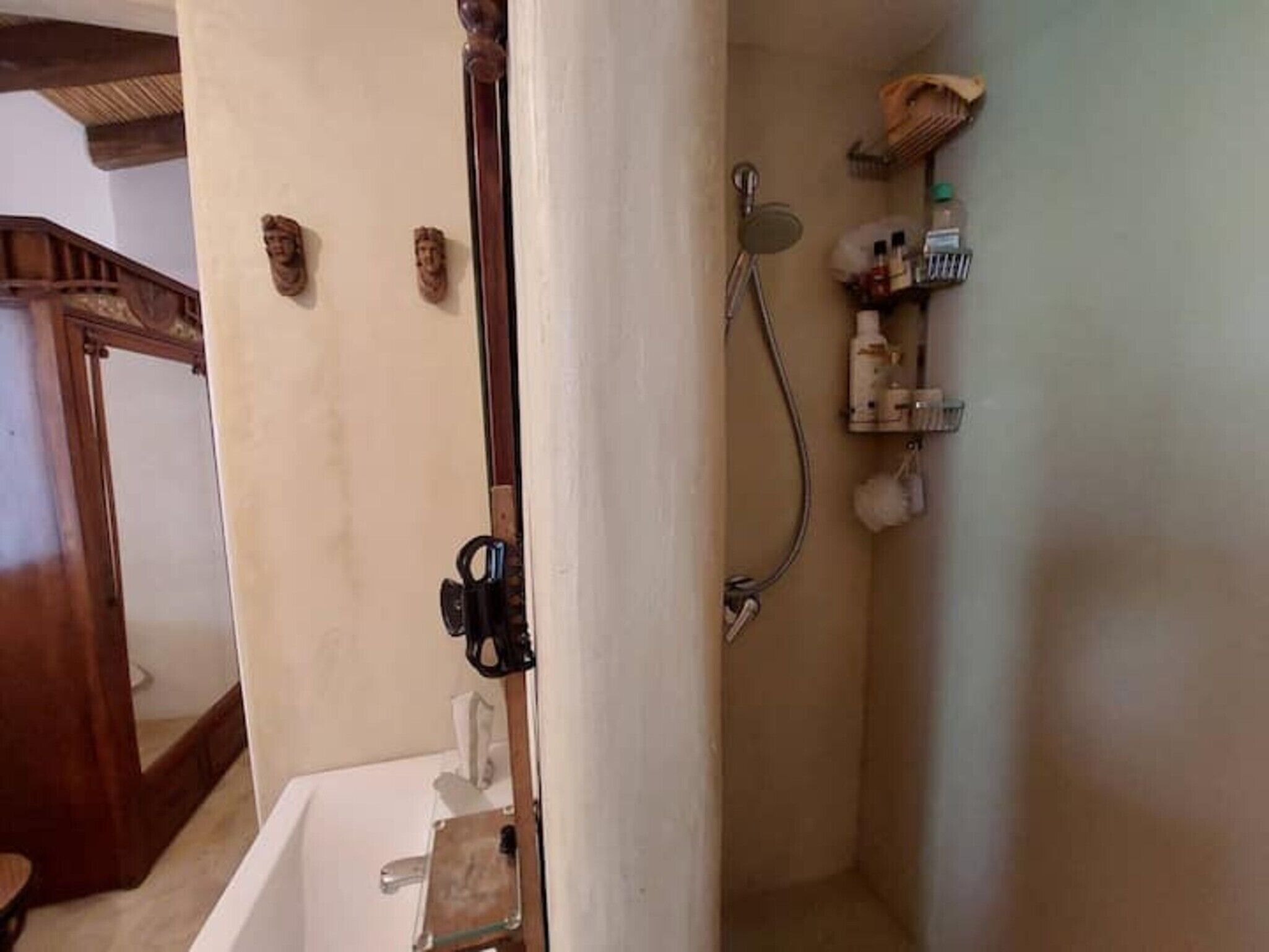 Un bagno con vasca, doccia e porta asciugamani.