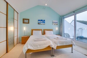 A bedroom with two beds, a sliding door, and a view of the outside. - 1 Bed in St Ives (oc-nicc41) (Saint Ives)