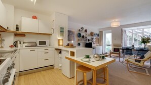 Eine moderne Küche mit weißen Schränken, einem Holzespeisetisch und einem eingebauten Backofen.