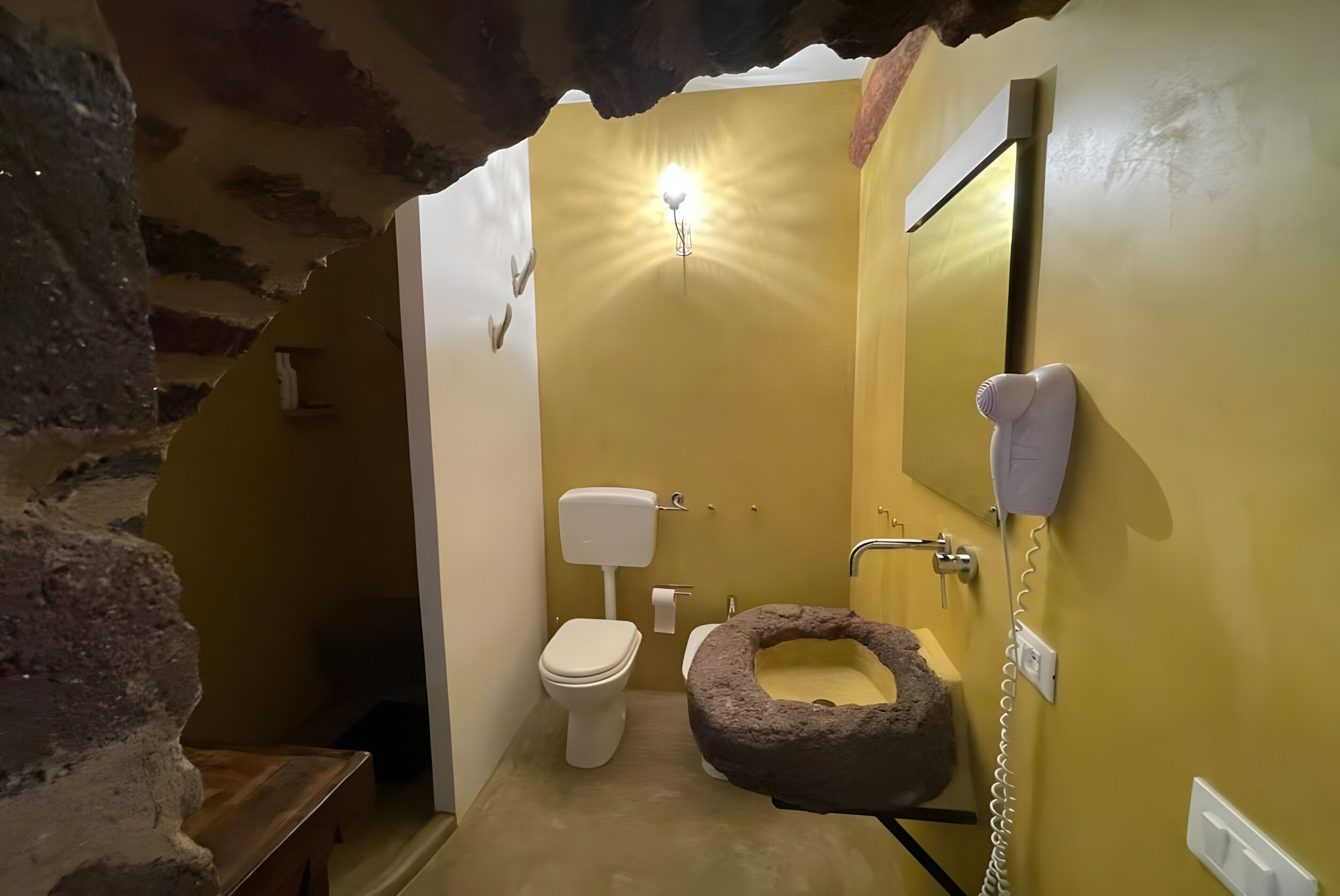 Een badkamer met toilet, wastafel en een bijzonder huisdierenbed.