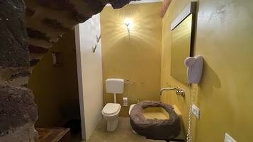 Een badkamer met toilet, wastafel en een bijzonder huisdierenbed.