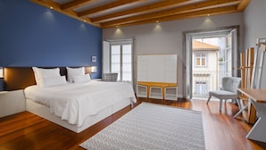 Une chambre à coucher avec un lit, un bureau, une chaise et une vue sur l’extérieur.
