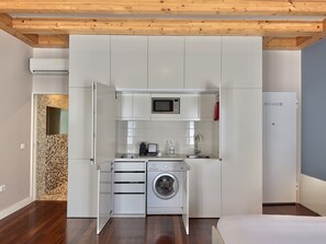 A compact kitchen with a microwave, sink, and built-in washing machine. - Stylish Studio with balcony for 3 in Taipas Center (Oporto)