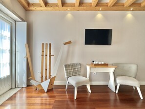 A room with wooden beams on the ceiling, a white sofa, two chairs, a small table with cups, and a painting on the wall. - Stylish Studio with balcony for 3 in Taipas Center (Oporto)