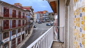 Straatbeeld vanaf een balkon, met gebouwen in traditionele architectuur en een geplaveid straatje.