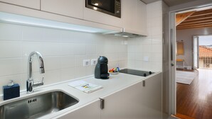 Een moderne keuken met witte kastjes, roestvrijstalen apparatuur en een ingebouwde magnetron.
