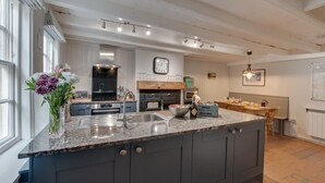 A modern kitchen with granite countertops, a central island, and a built-in oven. - 3 Bed in Robin Hoods Bay (oc-r041) (Robin Hood's Bay)