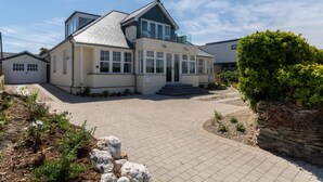 Ein zweigeschossiges Haus mit gepflasterter Auffahrt, Garage und einem gepflegten Garten.
