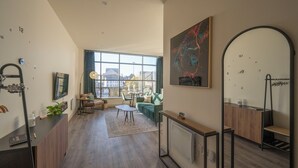 Un salon moderne avec une grande fenêtre, un canapé, une table basse et un coin repas.