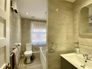 Ein modernes Badezimmer mit Toilette, Bidet und Badewanne.