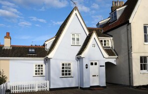A traditional white building with a steeply pitched roof, a white door, and a small window. - 2 Bed in Southwold (oc-aaheat) (Southwold)