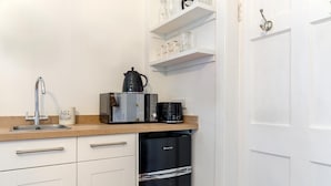 A modern kitchen with a stainless steel sink, a coffee maker, a toaster, and a dishwasher. - 1 Bed in Wells-next-the-Sea (oc-1939) (Wells-next-the-Sea)