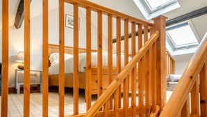 A bedroom with a wooden staircase, a bed, a bedside table, and a lamp. - 1 Bed in Powburn (oc-nb662) (Ilderton)