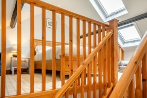 A bedroom with a wooden staircase, a bed, a bedside table, and a lamp. - 1 Bed in Powburn (oc-nb662) (Ilderton)