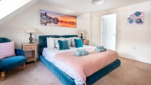 A bedroom with a bed, two bedside tables, a nightstand, a window, and a painting on the wall. - 4 Bed in Cromer (oc-1942) (Cromer)