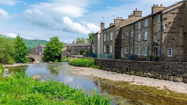 A stone bridge over a river, with stone buildings on one side and greenery on the other. - 2 Bed in Gayle (oc-ds912) (Hawes)