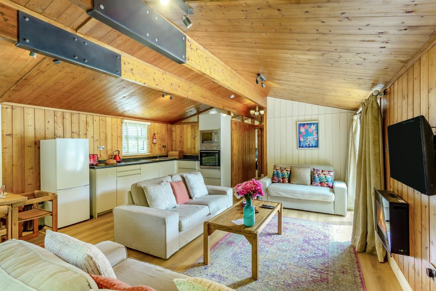 A spacious living area with a sofa set, a coffee table, and a television.