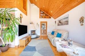 A cozy living room with a fireplace, a sofa, a television, and a bookshelf. - 2 Bed in Staithes (oc-wa071) (Staithes)
