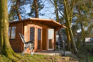 A small wooden cabin with a porch, a ladder, and a grill. - 3 Bed in Elsing (oc-1973) (Mill Street)