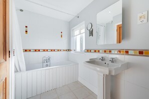 A modern bathroom with a bathtub, a sink, and a shower. - 4 Bed in Southwold (oc-hhigh) (Southwold)