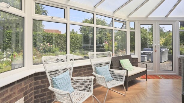 A conservatory with large windows, wicker chairs, a sofa, and a view of a garden. - 5 Bed in Walberswick (oc-hferin) (Walberswick)