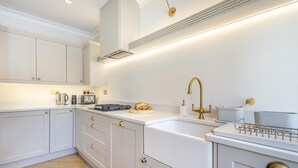 A modern kitchen with white cabinetry, a stainless steel range, a gold faucet, and a built-in oven. - 2 Bed in Walberswick (oc-hstone) (Walberswick)