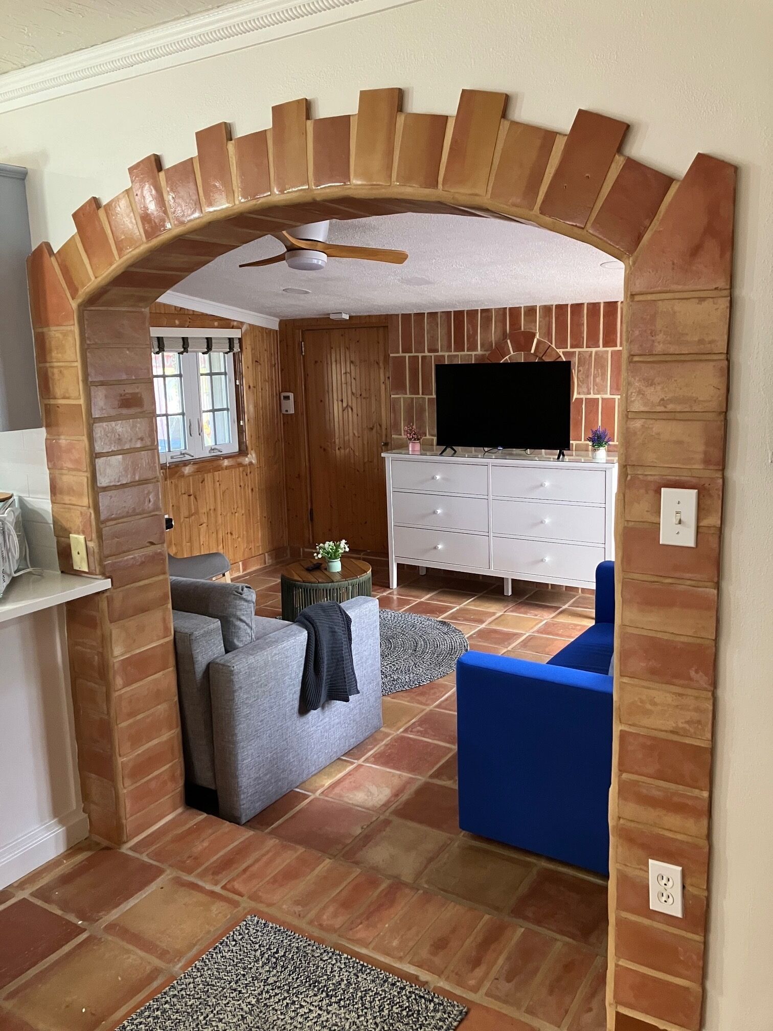 A living room with a TV, sofas, and a fireplace.