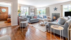 Ein Wohnzimmer mit Kamin, Sofas, einem Couchtisch und einem Fernseher.