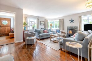 A living room with a fireplace, sofas, a coffee table, and a television. - 5 Bed in Walberswick (oc-hlodg2) (Walberswick)