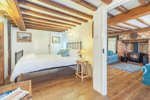 A bedroom with a bed, bedside table, and a wooden floor. - 3 Bed in Southwold (oc-hsmugg) (Southwold)