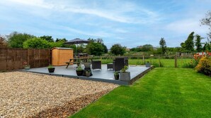A patio with outdoor furniture, a wooden shed, and a grassy lawn. - 4 Bed in Wrentham (oc-hdress) (Wrentham)