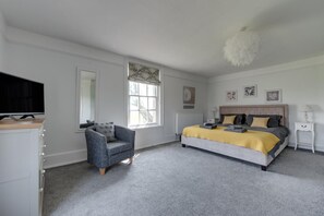 A bedroom with a bed, a chair, a television, and a window. - 6 Bed in Nr Southwold (oc-hohall) (Reydon)