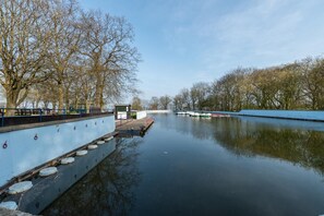 A calm river with boats docked on the left bank, surrounded by trees and a clear sky. - 4 Bed in Filey (oc-sa018) (Filey)