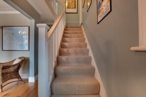 A staircase with carpeted steps, white railings, and a wall with framed artwork. - 4 Bed in Filey (oc-sa018) (Filey)