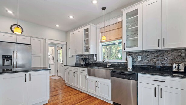 A modern kitchen with white cabinets, stainless steel appliances, and a black countertop. - Historic Comfort l Walk to DNTN l Fire Pit (St. Augustine)