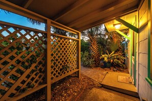 A covered outdoor area with a wooden lattice fence, a pathway, and potted plants. - Beachcomber Oasis l 1930s Cottage l 1 min to Beach (St. Augustine)