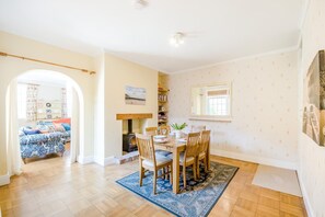 A dining area with a table set for four, a bookshelf, and a fireplace. - 3 Bed in Scarborough (oc-s018) (Scarborough)