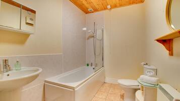 A bathroom with a bathtub, a toilet, and a sink.