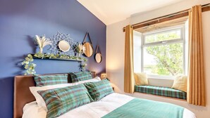 Una camera da letto con un letto, una panca finestrata e decorazioni a parete.