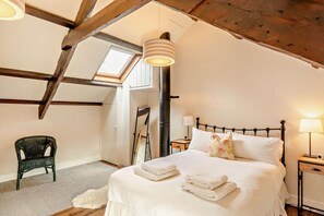 A bedroom with a bed, two bedside tables, a chair, a mirror, and a skylight. - 4 Bed in Wooler (oc-196438) (Akeld)
