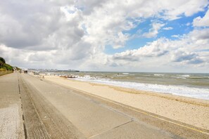 Eine Küstenstraße mit Strand und einem Pier in der Ferne.