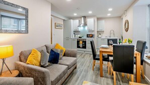 Ein modernes Apartment mit Wohnzimmer, Essbereich und Küche.