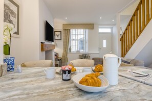 A living room with a marble coffee table, a television, and a staircase. - 1 Bed in Conwy (oc-bow117) (Conwy)