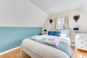 Une chambre à coucher avec un lit, des tables de chevet et une fenêtre.