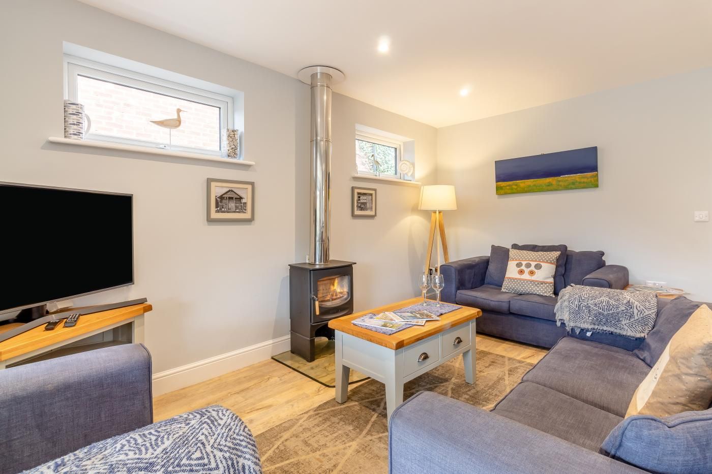 A living room with a television, sofa, and a fireplace.